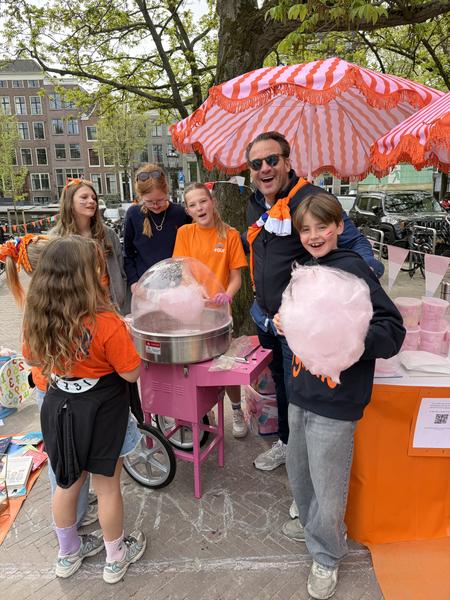 A family enjoying cotton candy at an outdoor street festival
